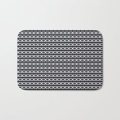 a black and white bath mat with an oval design on the bottom, in front of a white background