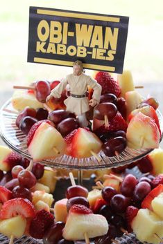 a star wars dessert is displayed on a plate with strawberries, grapes and bananas