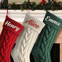 three stockings hanging from a mantel decorated with holly and red, white and green stocking