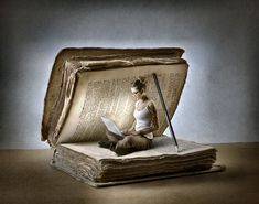 a woman sitting on top of an open book