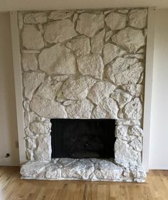 an empty living room with a stone fireplace