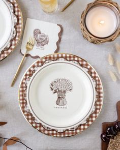 the table is set for thanksgiving dinner with turkey place settings and napkins on it