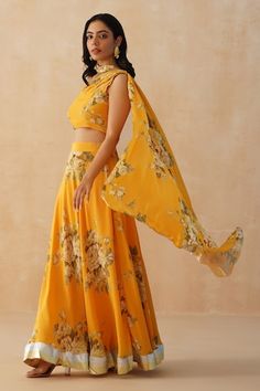 Mustard lehenga with all over floral print and lace embroidered hem. Paired with a padded blouse with matching print and draped one shoulder pallu. - Aza Fashions Fitted Georgette Choli With Printed Motifs, Yellow Lehenga With Cutdana And Traditional Drape, Yellow Floral Print Dupatta With Traditional Drape, Semi-stitched Yellow Lehenga With Motifs, Pink Floral Print Lehenga With Traditional Drape, Fitted Yellow Sharara With Floral Print, Floral Print Yellow Lehenga, Cape Lehenga, Kurta Lehenga