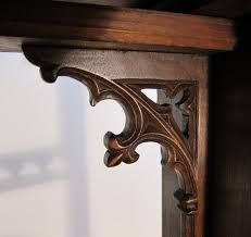 an ornate wooden shelf with mirror in the corner and light shining on it's side