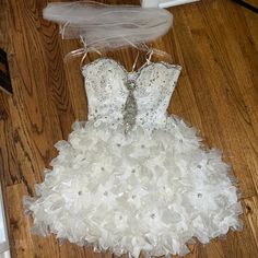 Worn Once Homecoming Dress With Feather/Bow/Flower Bottom. Slight Self Tanner Stains On Inside As Pictured Comes With Arm Wrap Never Worn. Sleeveless Feather Trim Dress For Homecoming, Fitted Feather Dresses For Homecoming, White Homecoming Dress With Ruffles, White Ruffled Dress For Homecoming, White Ruffled Homecoming Dress, Feather Trim Dresses For Homecoming And Prom Season, Feather Trim Dress For Homecoming And Prom Season, Feather Trim Dress For Homecoming And Prom, Feathered Dresses For Wedding And Prom Season