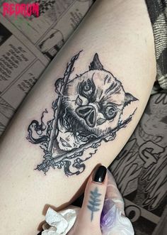 a woman's leg with a tattoo on it that has an image of a cat