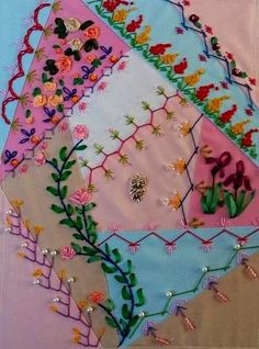 an embroidered piece of cloth with flowers and plants on it