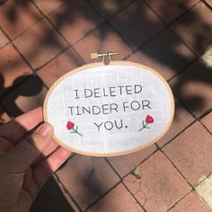 someone is holding up a cross - stitch sign that says i deleted tinder for you