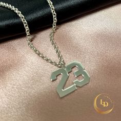 This Mens Number Necklace is a striking, unique piece of personalized jewelry that will make a statement.  Available in either sterling silver or 24K gold plated, this custom Boys Number Pendant is perfect for adding a personal touch to any outfit.  The necklace features a sturdy Rolo Chain that complements the pendant beautifully.  Treat yourself or a loved one to this special and meaningful piece, which makes for a thoughtful and stylish gift. M A T E R I A L S: Style: Number Necklace. Materia Custom Pendant, Number Necklace, Silver Numbers, Gifts For Sports Fans, Custom Pendants, Necklace Unique, Mens Pendant, Sterling Silver Mens, Rolo Chain