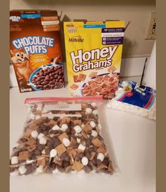 some cereal and marshmallows are sitting on the counter next to each other