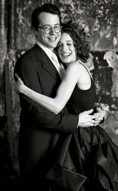 a man and woman hugging each other in black and white