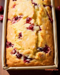 a loaf of cranberry bread in a pan on top of a wooden table