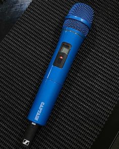 a blue microphone sitting on top of a black surface