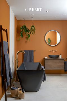 a bathroom with orange walls and black tub