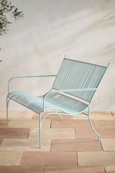 a blue bench sitting on top of a tiled floor next to a potted plant