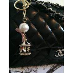 Super cute and chic! Black and white topped carousel with little details inside, like a 5, a lipstick, a camellia flower, a star, and a little purse! Pearl and pink bow at the top. Gold hardware, with a keyring and a clip.  * I can send this with or without the extra pink bow in the last pic. Just let me know. :) Camellia Flower, Clover Necklace, Pink Bow, Carousel, Key Chain, Chain Bracelet, Gold Hardware, Keychains, Let Me