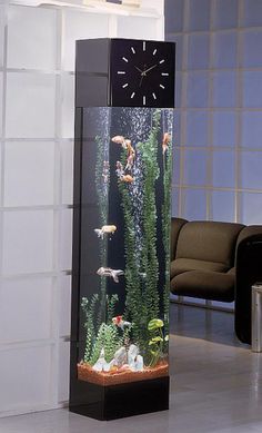 an aquarium with fish and plants in it is on the floor next to a chair