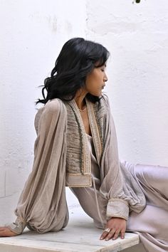 The Meraki jacket is the perfect addition to your wardrobe for a light weight layer than can be dressed up or down easily. Featuring exquisite hand embellished details and lined edging this light weight raw silk body blouses beautifully and allows for comfortable movement.  Size | One Size  AUS 8 - 12 UK  8 - 13 US 4 - 8 EU 36 - 40 Fit |  *cropped at mid waist *Relaxed fit *Balloon sleeves - generous blouse  Fabric | Features  *Hand loomed + hand dyed raw silk  *beaded fringing details  Paired w Sets With Blouson Long Sleeves, Bohemian Spring Sets With Embroidered Sleeves, Bohemian Sets With Embroidered Sleeves For Spring, Elegant Long Sleeve Sets With Draped Sleeves, Elegant Sets With Draped Long Sleeves, Spring Sets With Embroidered Long Sleeves, Festive Long Sleeve Silk Outerwear, Long Sleeve Sets For Fall Evening, Fall Silk Sets With Long Sleeves