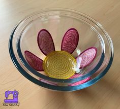 a glass bowl filled with flowers on top of a wooden table