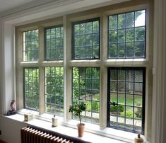 a room with four windows and two radiators on the wall, in front of them