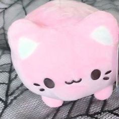 a pink stuffed animal with eyes and ears