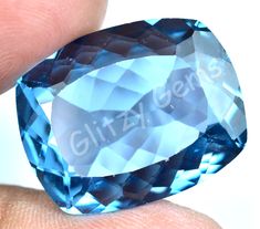 a blue diamond is being held by someone's hand in front of the camera