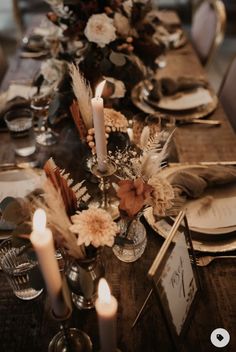 the table is set with candles, plates and napkins for an elegant fall dinner