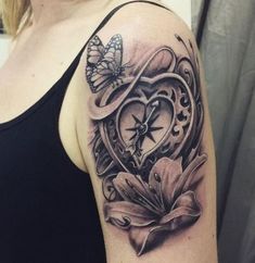 a woman's arm with a clock and flower tattoo design on the left shoulder