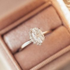 an engagement ring in a box on top of a table