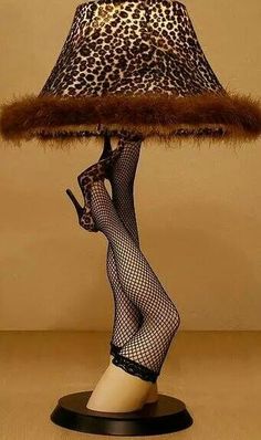 a lamp with a leopard print shade on it and a woman's legs in fishnet stockings