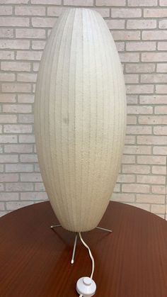 a white lamp sitting on top of a wooden table