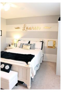 a white bed sitting in a bedroom next to a wall mounted art on the wall