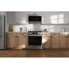 a kitchen with white cabinets and stainless steel appliances