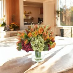 a vase filled with flowers sitting on top of a wooden table