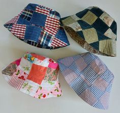 three hats are laying next to each other on the floor, one has a patchwork pattern