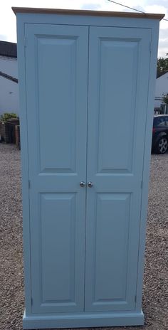 a tall blue cabinet sitting in the middle of a parking lot