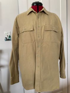 "Here is an L.L. Bean chamois shirt is khaki/ tan. It is made of cotton and is marked a size large. It measures approximately 48\" at the chest, 19\" across the shoulders, 23\" arm length, 7.5\" shoulder seam and 31\" center back length. It has some spots of discoloration on the right and left cuff and a small smudge on the left side about 5\" down from the pocket. Please see pictures." Chamois Shirt, Tan Shirt, Vintage Ll Bean, Ll Bean, L L Bean, Flannel Shirt, Ups, Float, Wool Blend