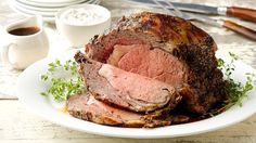 a roast beef on a white plate with garnish