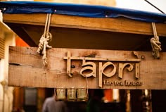 a sign hanging from the side of a building that says tappi tea house on it