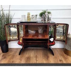 a wooden cabinet with two mirrors on the front and one door open to reveal a wine glass display