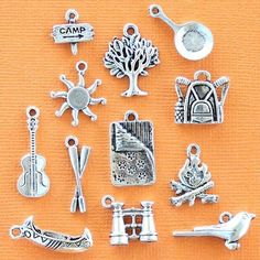 there are many different charms on the table with orange cloth behind them and an orange background