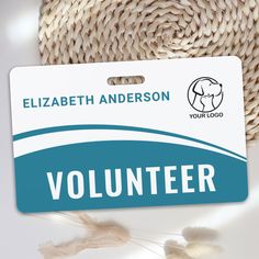 a volunteer badge sitting on top of a white table next to a straw hat and yarn