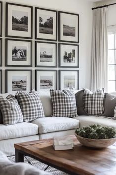 a living room with couches and pictures on the wall above them, along with a coffee table