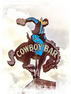 the cowboy bar sign is painted on top of a horse and has a hat on it's head