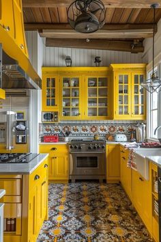 a kitchen with yellow cabinets and tile flooring in it's center, along with a chandelier hanging from the ceiling