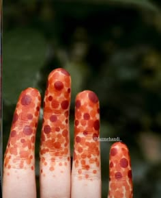 a person's hand with orange and red dots on it