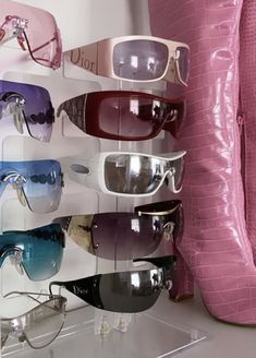 several pairs of pink boots and sunglasses on display