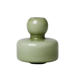 a green vase sitting on top of a white table