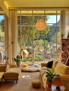 a living room filled with lots of furniture and large windows overlooking a garden area in the background