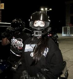 a woman sitting on top of a motorcycle wearing a helmet